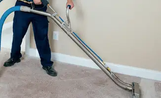 Professional operating a liquid removal machine on a carpeted floor in Arlington, TX